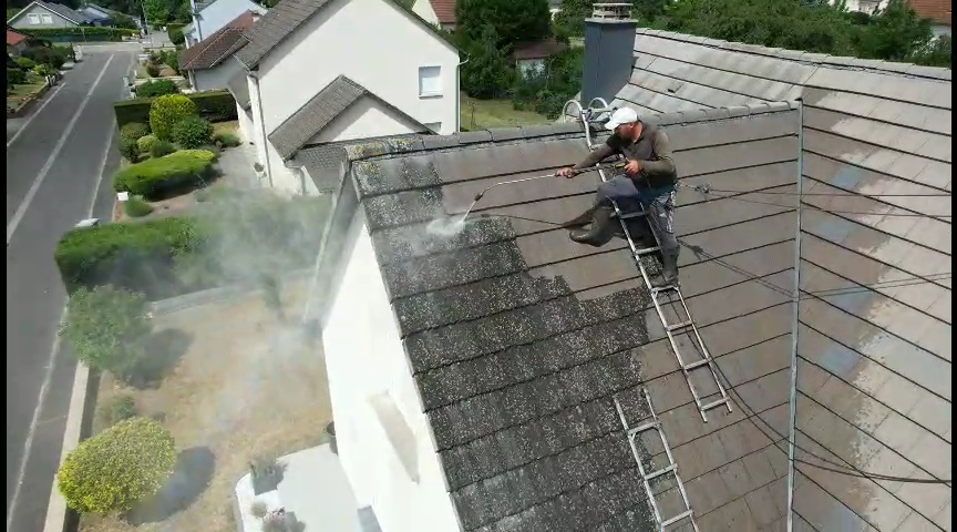 Artisan couvreur Pro Toiture KOEBEL : Nettoyage haute pression sécurisé avec harnais sur toiture à Metz.